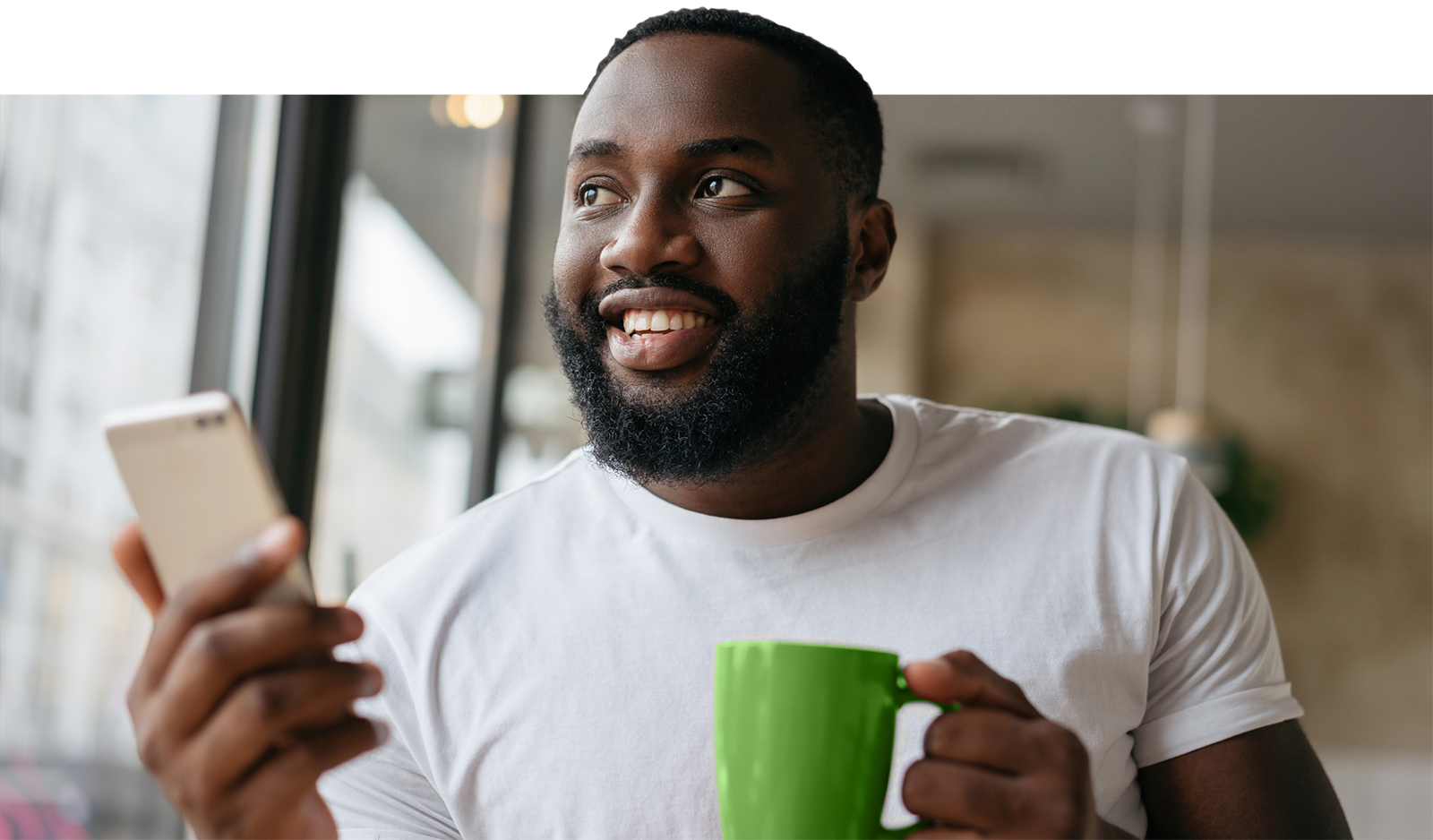 Man holding green mug on the phone